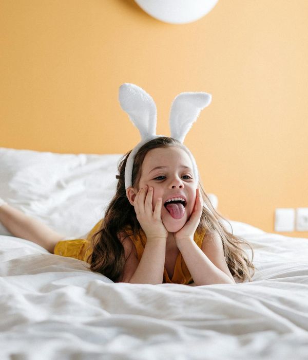 Happy child in a playful yoga tree pose in a bright room.